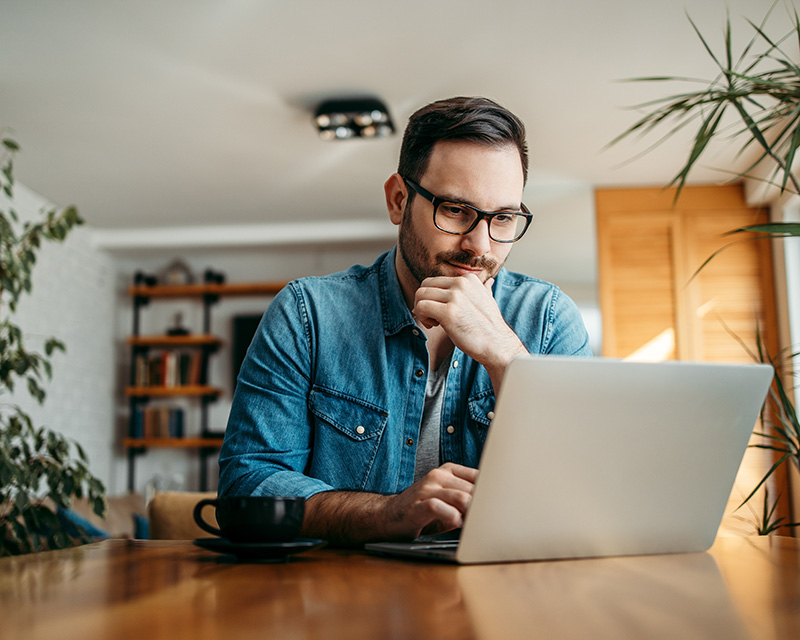 Man on a laptop at home having individual online therapy in New York